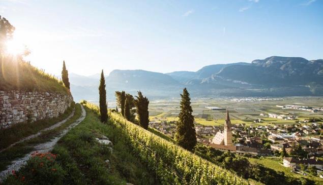 Vista da un percorso escursionistico su un villaggio in Alto Adige al sole.